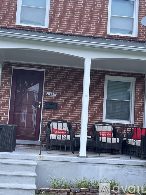 A red brick house with a black gate and a sign that says "My Son".