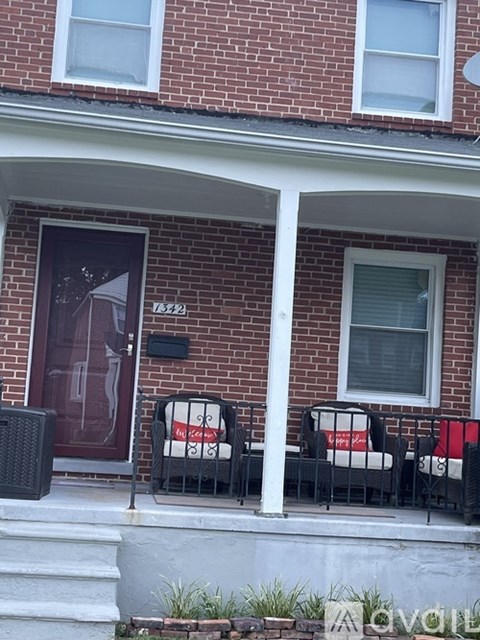 A red brick house with a black gate and a sign that says "My Son".