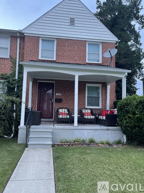A house with a red brick exterior and a white porch.
