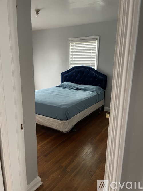 A bedroom with a bed and a window.