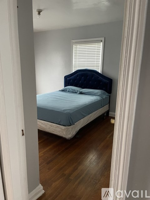 A bedroom with a bed and a window.