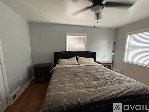 A bedroom with a bed, nightstand, and window.