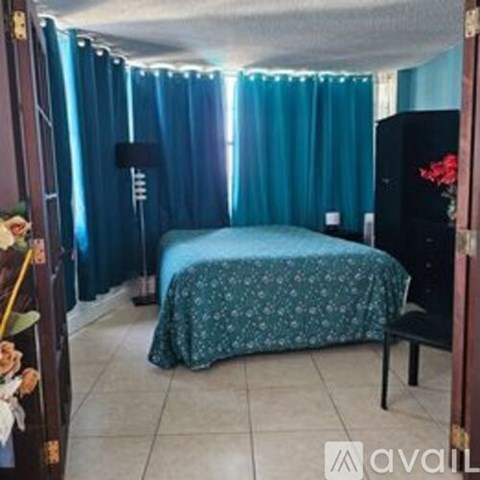 A bedroom with a bed and a dresser with a mirror.