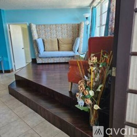 A living room with a couch and a flower arrangement on a table.