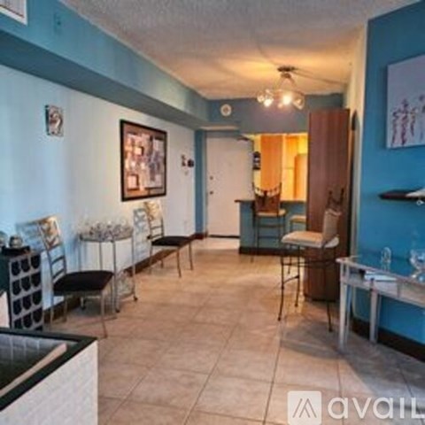 A room with blue walls and a white ceiling has a table and chairs in it.