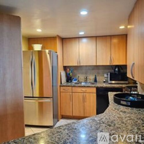 A kitchen with wooden cabinets and a granite countertop.