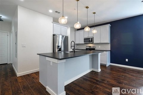 A kitchen with a dark wood floor and white cabinets.