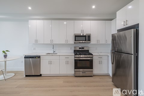 A modern kitchen with stainless steel appliances and white cabinets.