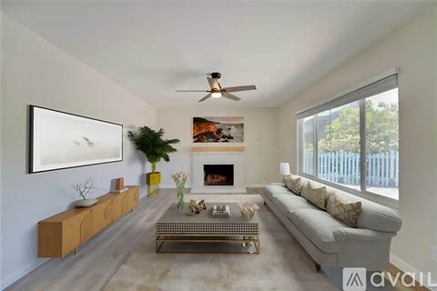 A living room with a fireplace, a couch, and a painting on the wall.