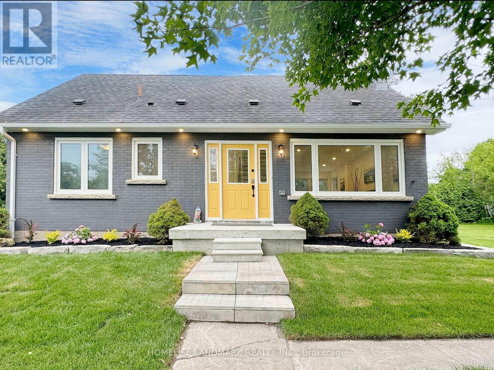 A house with a yellow door and a well-maintained lawn.