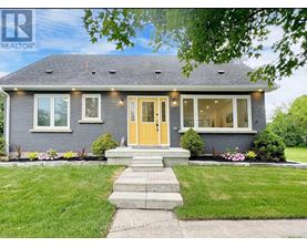 A house with a yellow door and a well-maintained lawn.