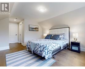 A bedroom with a large bed and a painting on the wall.