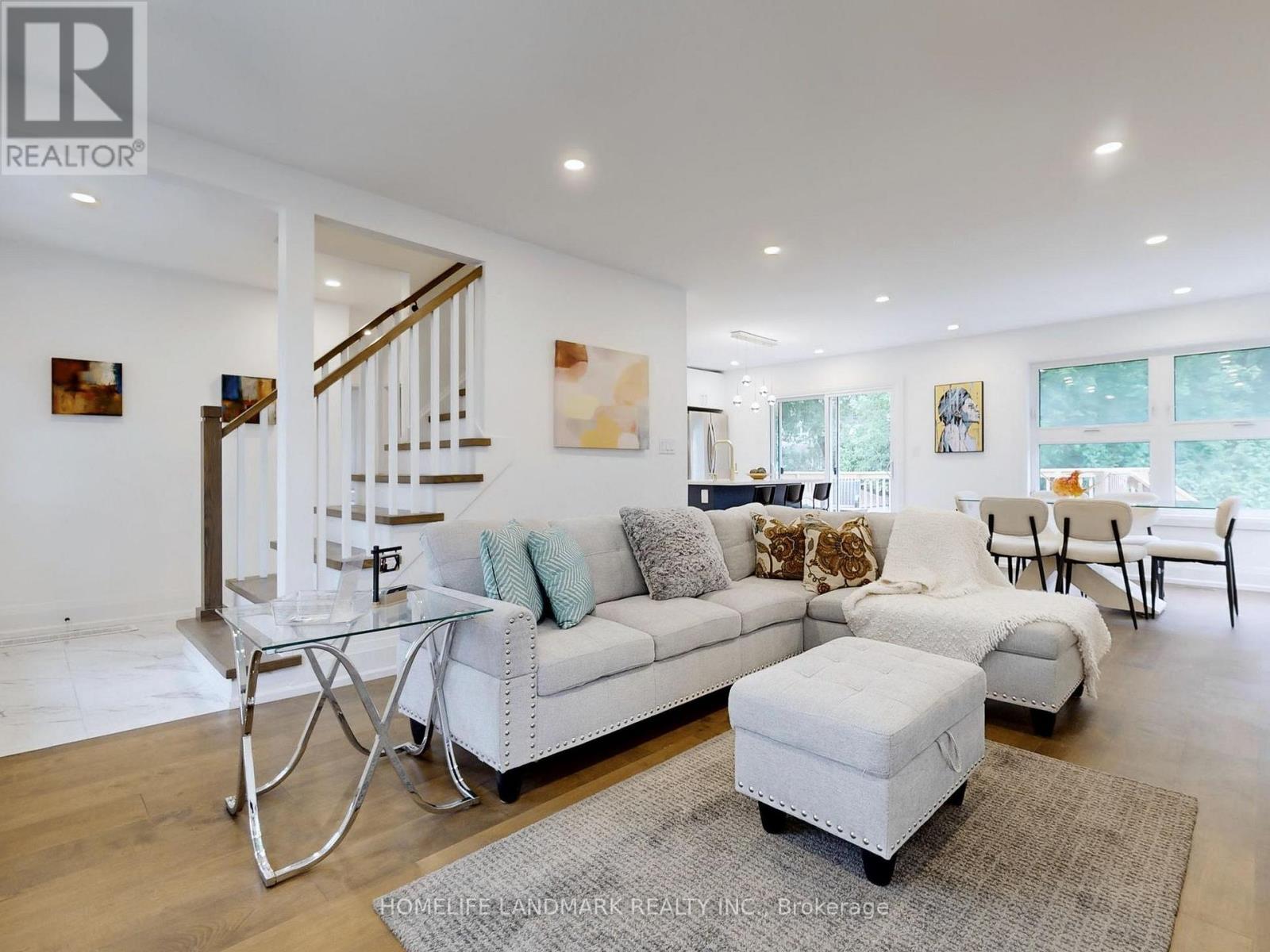 A spacious living room with a white couch and a glass coffee table.