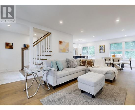 A spacious living room with a white couch and a glass coffee table.