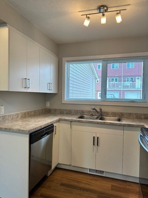 A kitchen with white cabinets and a granite countertop.