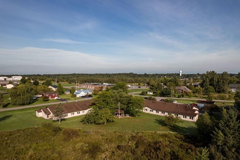 A large building complex with a green lawn in front.