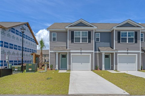 A two-story house with a garage is under construction.