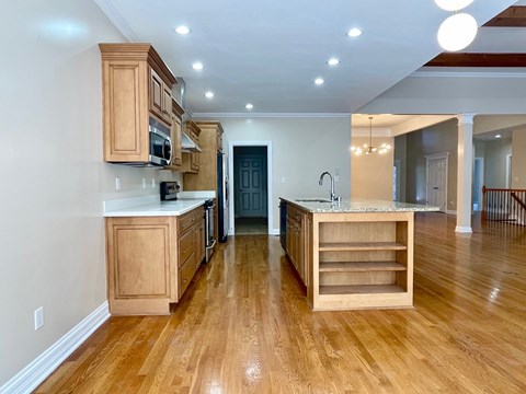 A kitchen with wooden cabinets and a marble countertop.