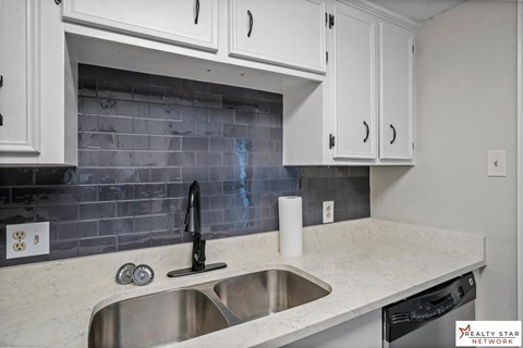 A kitchen with a sink and a dishwasher.