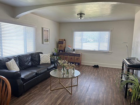 A living room with a black couch and a coffee table.