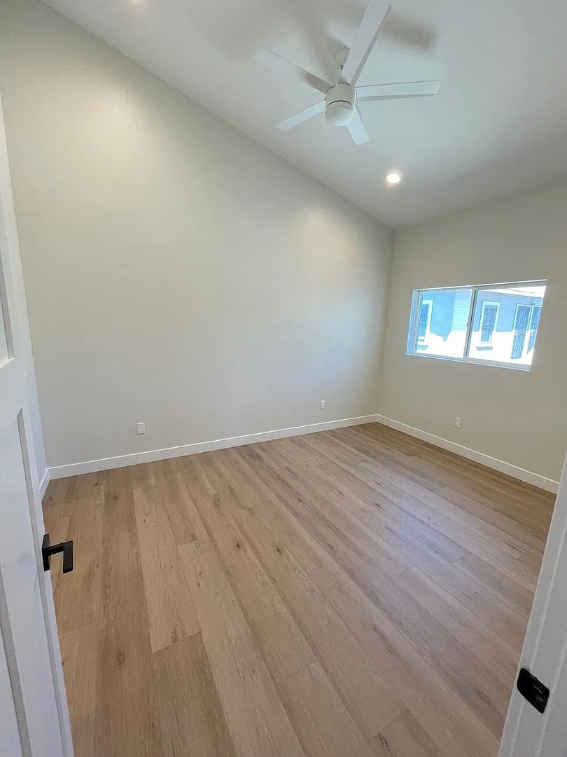 A room with a ceiling fan and a window.
