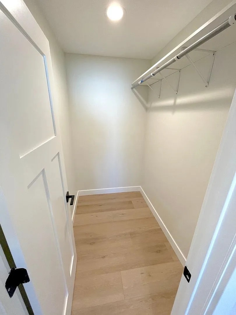 A hallway with a white door and a light on the ceiling.