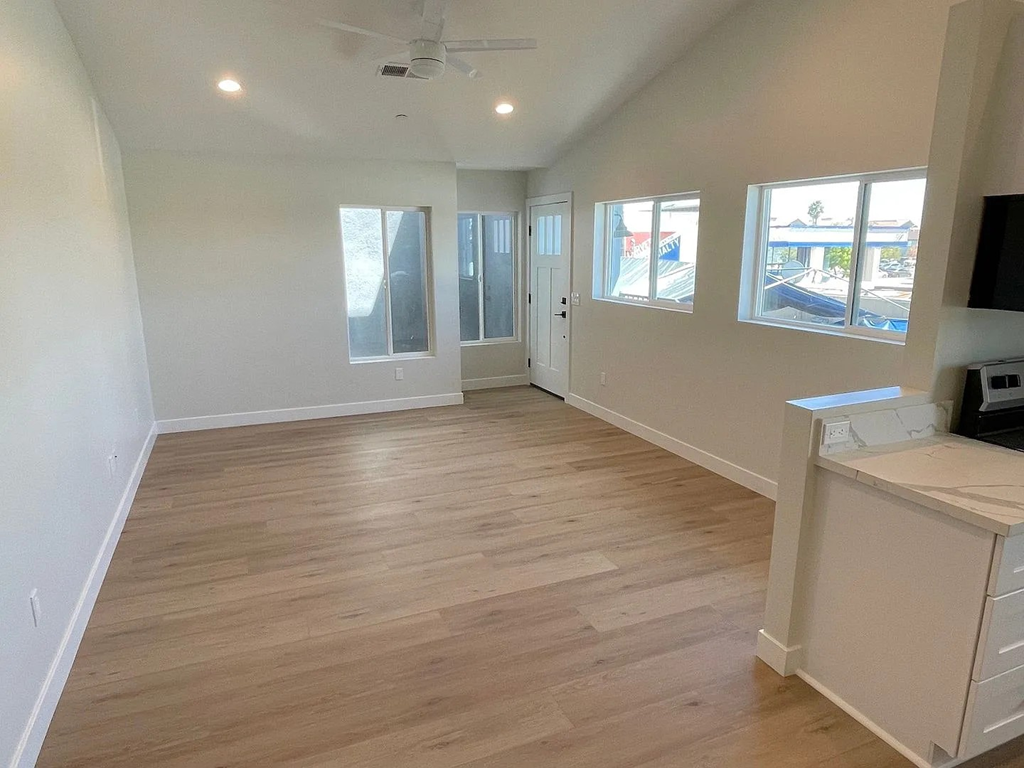 A room with wooden flooring and a ceiling fan.