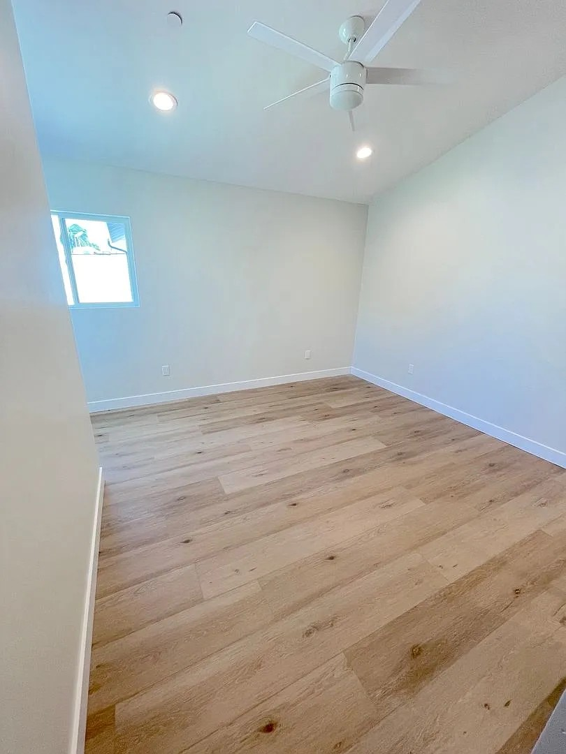 A room with wooden flooring and a ceiling fan.