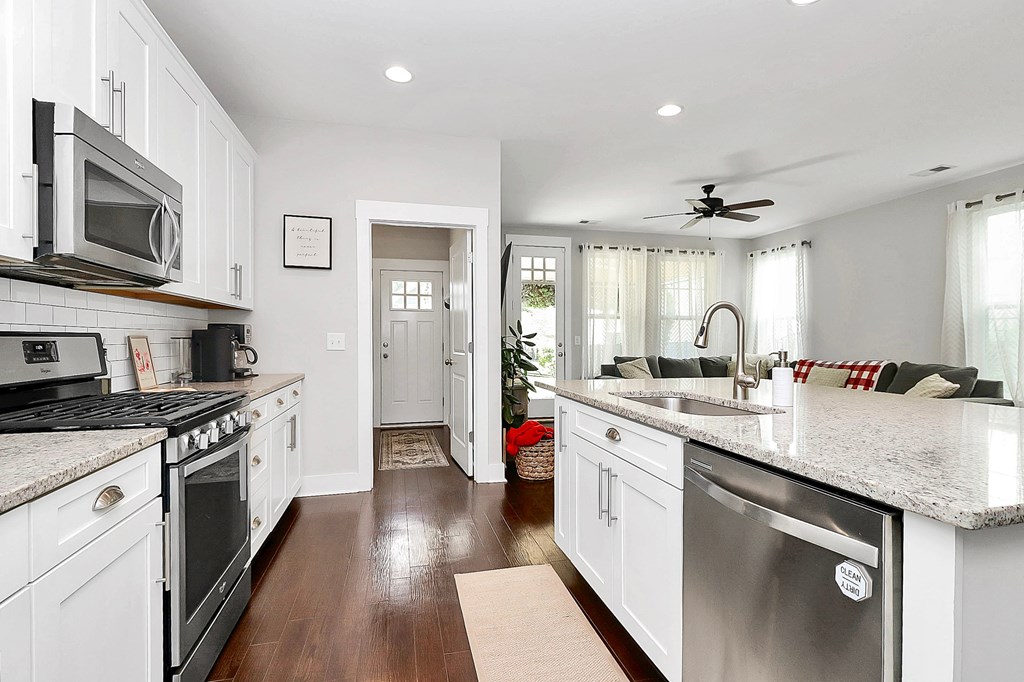 A kitchen with white cabinets and a stainless steel dishwasher.