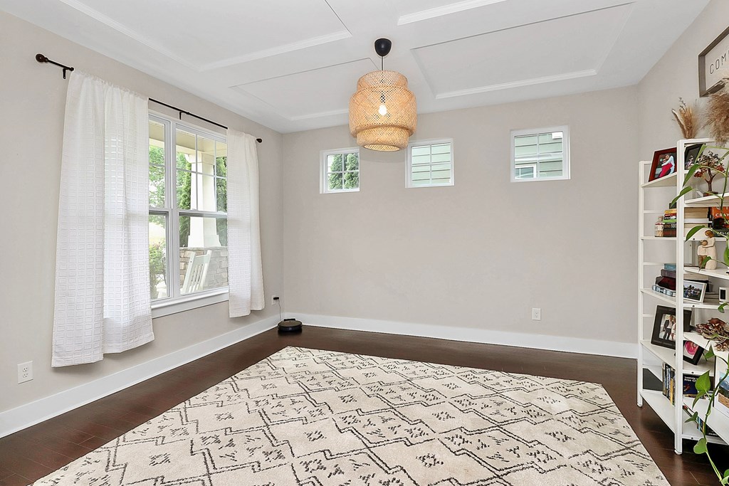 A room with a patterned rug on the floor and a hanging light fixture.