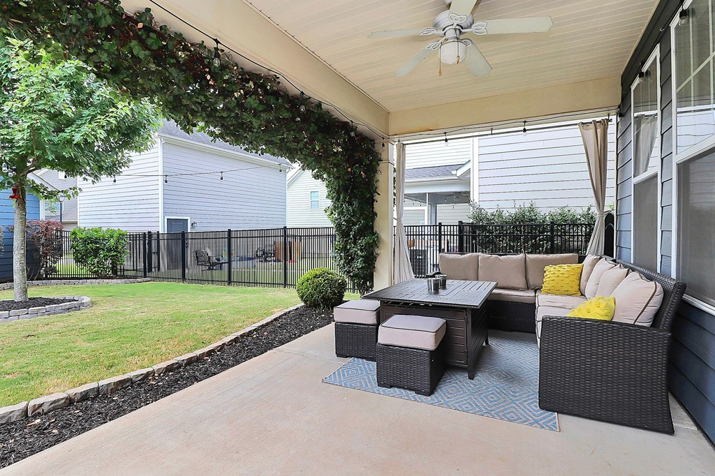 A patio with a table and chairs under a ceiling fan.