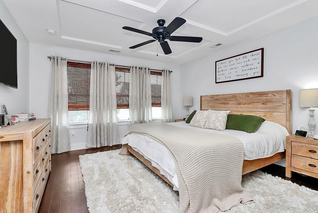 A bedroom with a large bed and a ceiling fan.