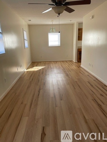 A room with wooden flooring and a ceiling fan.