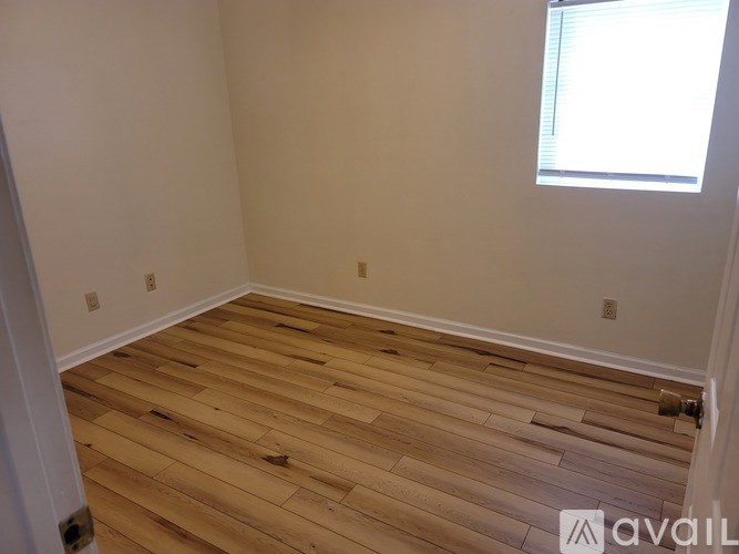 A room with wooden flooring and a window.