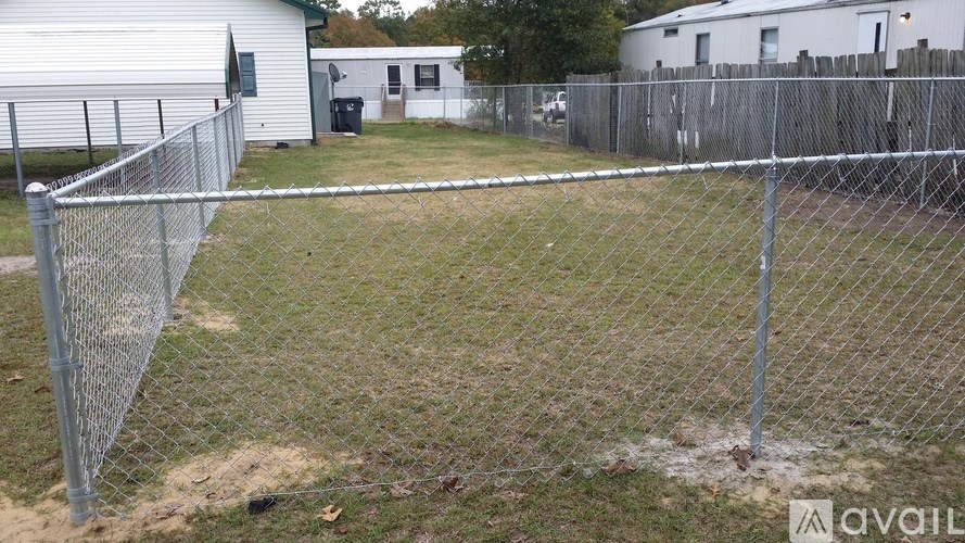 A chain link fence encloses a grassy area.