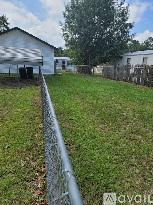 A fenced yard with a white building in the background.