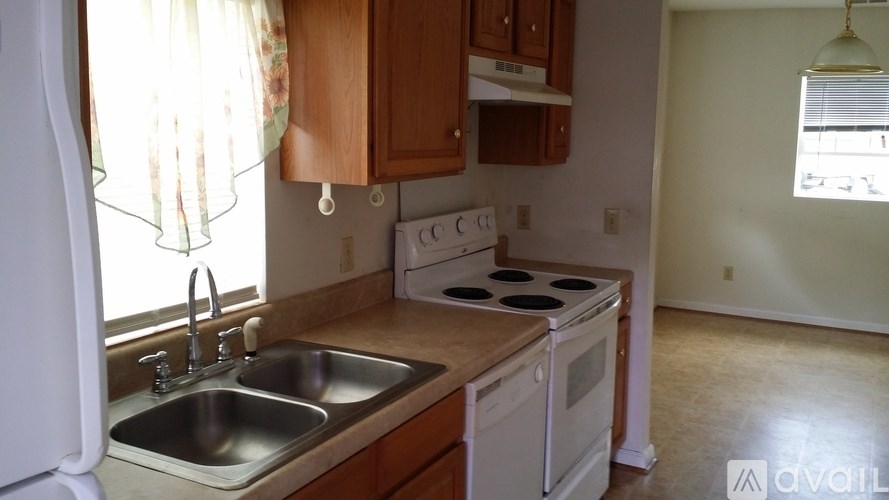 A kitchen with a white refrigerator, a white stove, and a white oven.