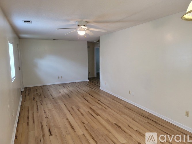 A room with wooden flooring and a ceiling fan.