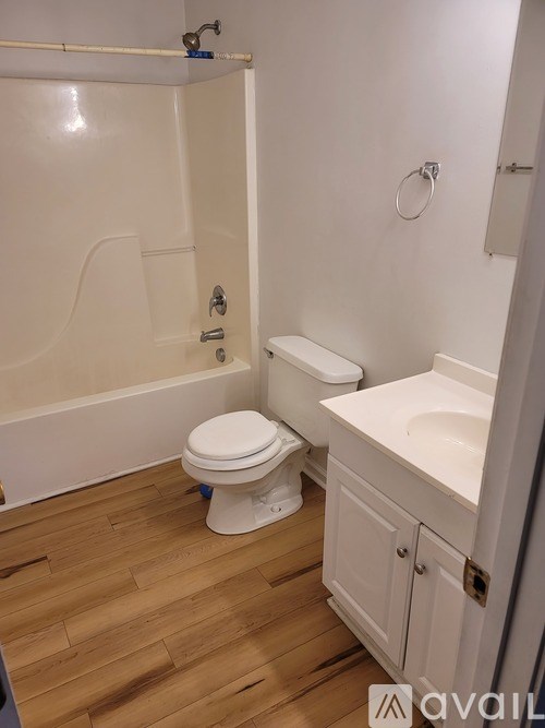 A white toilet sits in a bathroom next to a sink.