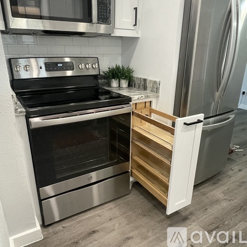 A modern kitchen with a stainless steel oven and refrigerator.