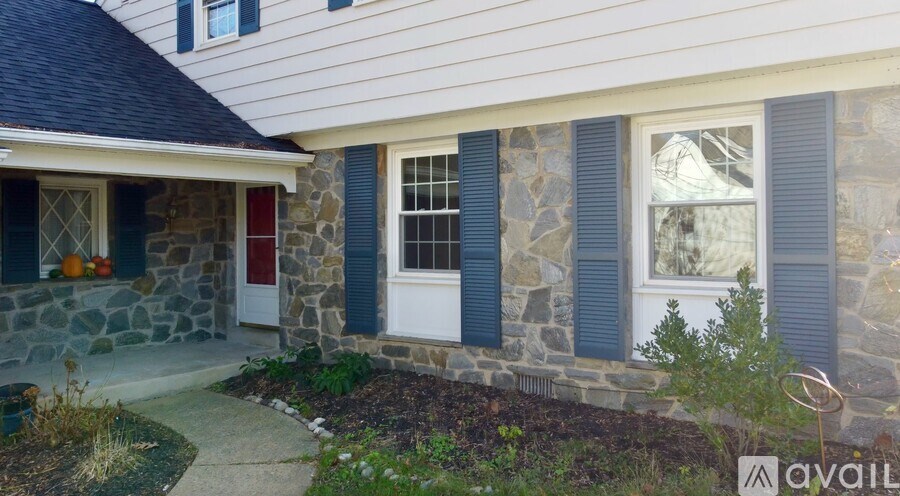 A house with a stone wall and a red door.