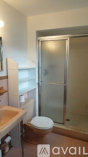 A bathroom with a toilet, sink, and shower.