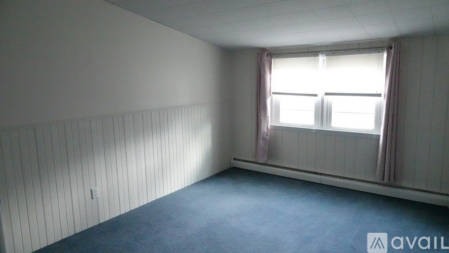 A room with a window and a wall covered in paneling.