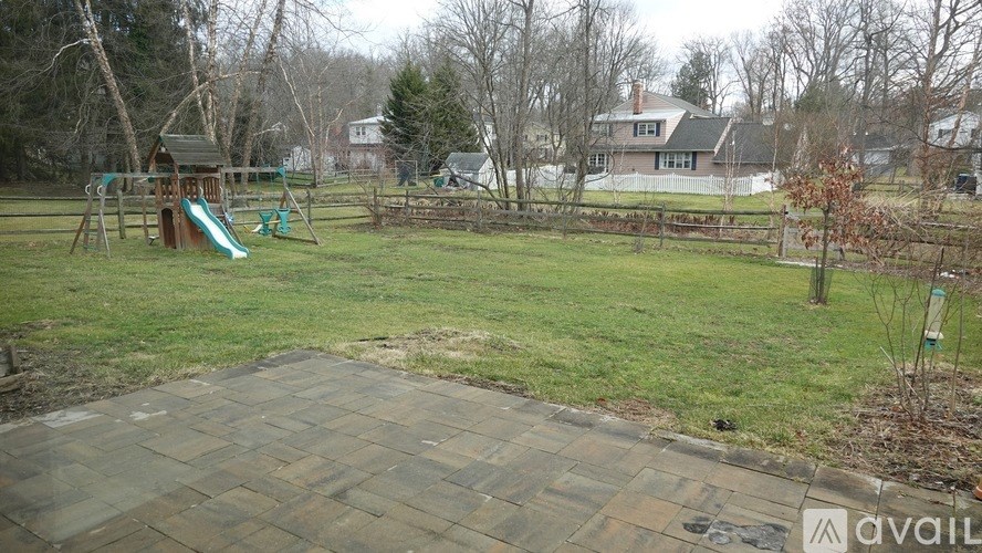 A backyard with a playground and a green slide.