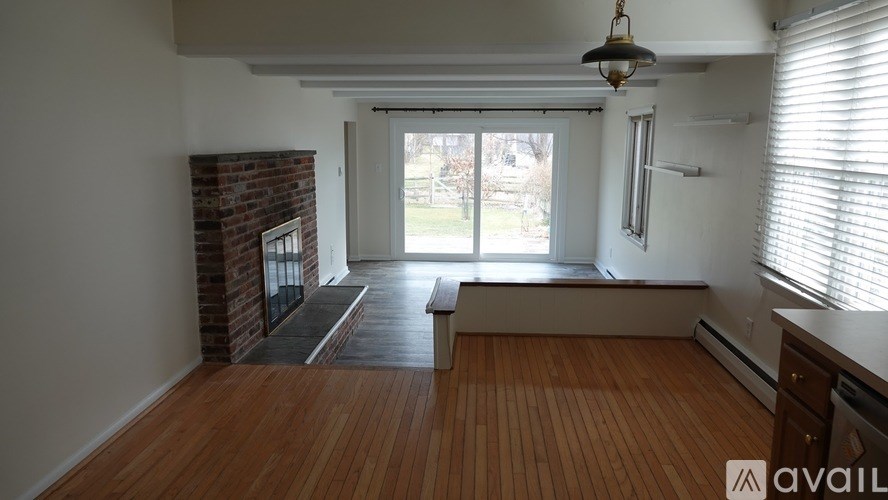 A room with wooden floors and a brick wall.