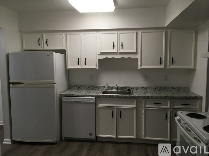 A kitchen with white cabinets and appliances.