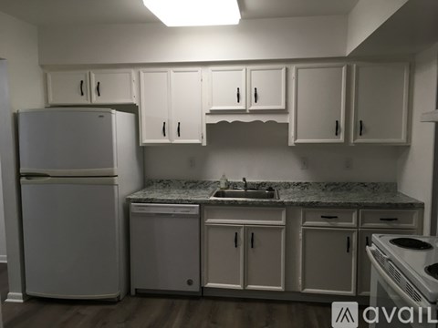 A kitchen with white cabinets and appliances.