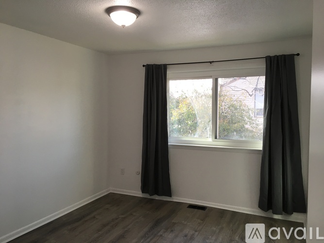 A room with a window and a grey curtain.