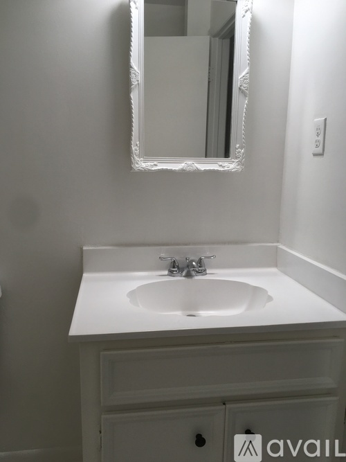 A white sink in a bathroom with a mirror above it.