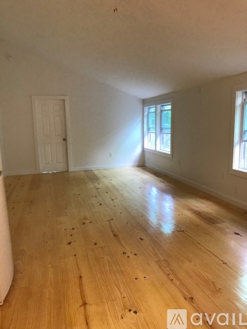 A room with wooden flooring and a ceiling fan.